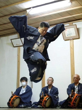 羽ばたくツルのように跳ね上がる踊り手＝住吉神社