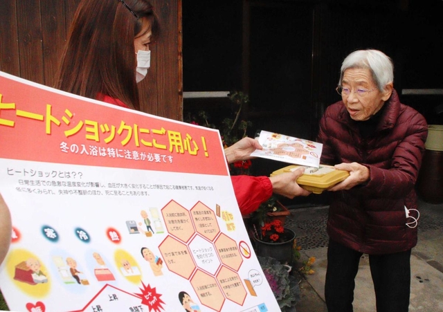 ヒートショック予防のチラシを渡す宅配弁当業者のスタッフ＝加古川市