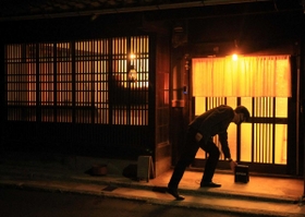 日が落ちる。格子窓から柔らかい明かりが漏れ、路地裏がオレンジ色に包まれる＝町家Ｔｅｎｔｏｆｕ（撮影・笠原次郎）