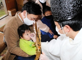 宮司に鼻をつままれる男児＝高砂市北浜町西浜、大歳神社