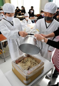 アルファ化米に湯を掛ける児童＝天満小学校