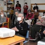 スクリーンに向かって拍手を送る利用者＝兵庫県稲美町国安、介護老人保健施設サンライズ