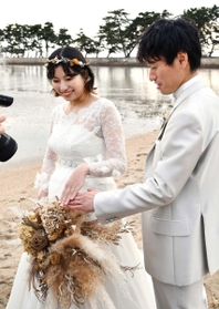 結婚指輪を撮影してもらう安東さん夫妻＝県立高砂海浜公園（高砂市提供）