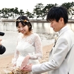 結婚指輪を撮影してもらう安東さん夫妻＝県立高砂海浜公園（高砂市提供）
