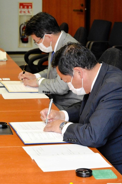 連携に関する協定書に調印する藤田佳男マルアイ会長兼社長（手前）と都倉達殊高砂市長＝同市役所