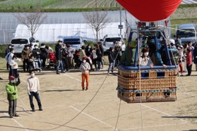 少しずつ高度が上がる熱気球。地上からも手を振ったり、記念撮影したりして楽しんだ＝加古川養護学校
