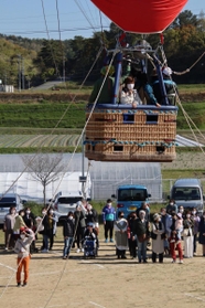 少しずつ高度が上がる熱気球。地上からも手を振ったり、記念撮影したりして楽しんだ＝加古川養護学校