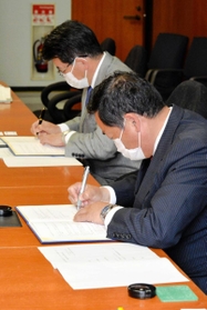 連携に関する協定書に調印する藤田佳男マルアイ会長兼社長（手前）と都倉達殊高砂市長＝同市役所