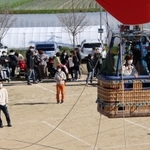 少しずつ高度が上がる熱気球。地上からも手を振ったり、記念撮影したりして楽しんだ＝加古川養護学校