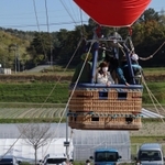 少しずつ高度が上がる熱気球。地上からも手を振ったり、記念撮影したりして楽しんだ＝加古川養護学校