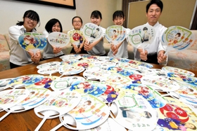 うちわのイラストを描いた氷丘中学校美術部員と禰宜の松崎正誠さん＝日岡神社