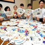 うちわのイラストを描いた氷丘中学校美術部員と禰宜の松崎正誠さん＝日岡神社