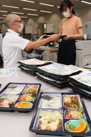 弁当を受け取る学生（右）ら＝兵庫大