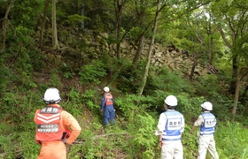 傾斜地の様子を確認する高砂市職員ら＝同市阿弥陀町
