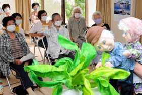 おおきなかぶの人形劇を楽しむ高齢者ら＝小松原自治会館