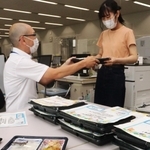 弁当を受け取る学生（右）ら＝兵庫大