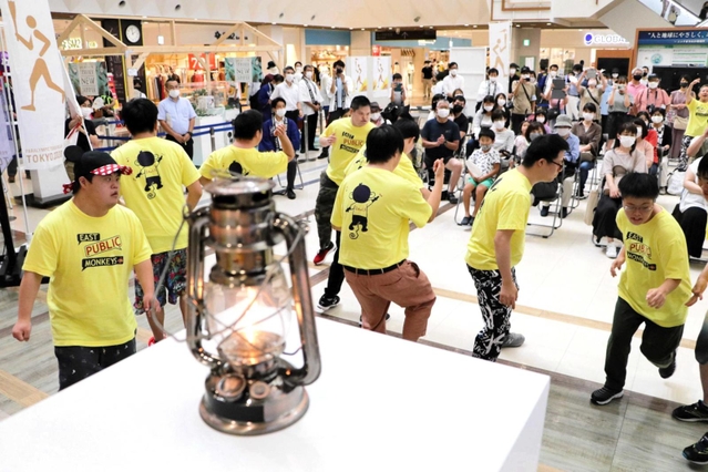 聖火のそばでダンスを披露するイーストパブリックモンキーズのメンバー＝ニッケパークタウン