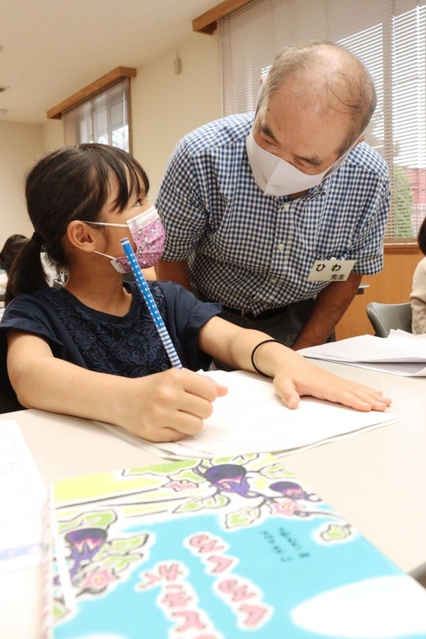 男性（右）から読書感想文の助言を受ける児童＝尾上公民館