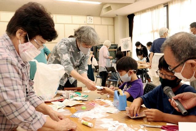 牛乳パックなどを使ってこまを作る児童ら＝野口公民館