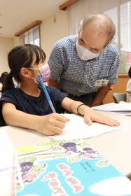 男性（右）から読書感想文の助言を受ける児童＝尾上公民館