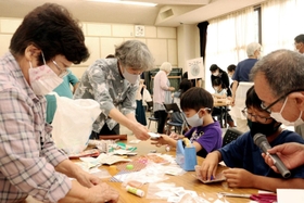 牛乳パックなどを使ってこまを作る児童ら＝野口公民館