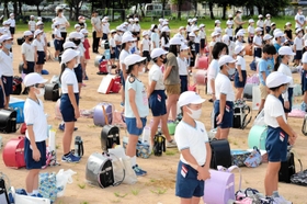 ランドセルや夏休みの宿題を脇に置いて始業式に臨む児童＝中筋小学校