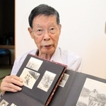 中国・鞍山市にいた頃の写真を示しながら、当時の体験を語る堀川哲男さん＝加古川市