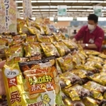 スーパーに山積みされた「サッポロポテトバーベＱあじ　加古川かつめし味」＝加古川市尾上町安田、マックスバリュ安田店