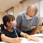 男性（右）から読書感想文の助言を受ける児童＝尾上公民館