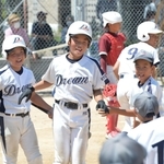 加古川ｂｂドリーム－播磨少年クラブ　三回表、本塁打を放って仲間に迎えられる岩井蓮選手（中央）。四回にも連続となる本塁打を決めた＝神戸市西区岩岡町岩岡、ＣＣＰグラウンド