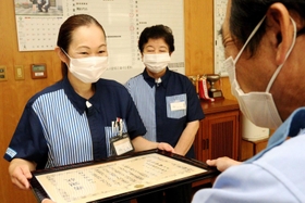 森本成治署長（右）から感謝状を受け取る小林温美さん（左）、オーナーの松本多鶴子さん＝高砂署