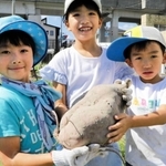 ４キロを超えるサツマイモを持つ（左から）梅田莉空ちゃん、福島凜美さん、綾士ちゃん＝加古川市加古川町美乃利