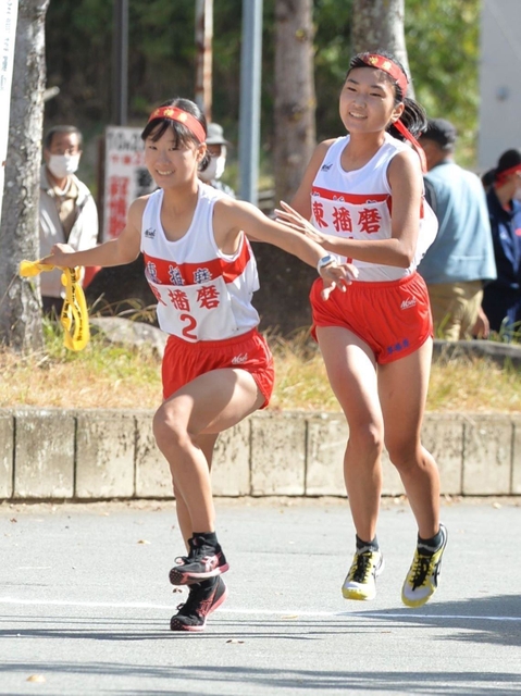 女子・東播磨の１区坂本幸妃音選手（右）からたすきを受け取り、走りだす２区の西尾わこと選手＝西脇市総合市民センター（撮影・笠原次郎）