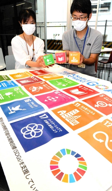 市民らに貸し出しているＳＤＧｓグッズを手に、実践例の応募を呼び掛ける職員＝高砂市役所