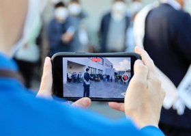 立候補者の街頭演説の動画を撮影する陣営スタッフ＝加古川市内（画像の一部を加工しています）