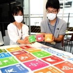 市民らに貸し出しているＳＤＧｓグッズを手に、実践例の応募を呼び掛ける職員＝高砂市役所