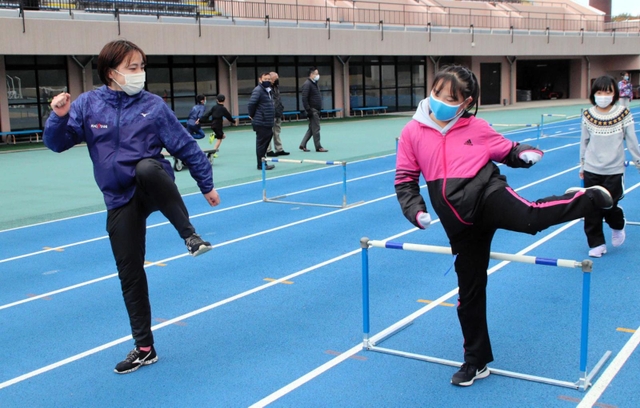 ハードルを跳ぶ際の脚の動きを教える横田華恋選手（左）＝加古川運動公園陸上競技場