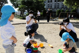 旧加古川図書館を背景に、周辺の日常を切り取るＰａｋｕ　Ｐａｋｕ　Ｐａｒｋのメンバーら＝金剛寺浦公園
