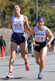 女子・加古川北の３区日高里菜選手（左）からたすきを受け取る４区内田茉凛選手＝丹波篠山市内（撮影・吉田敦史）