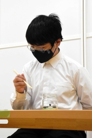 豆つかみでギネス世界記録に挑戦した狭間蒼心さん＝いなみっこ広場