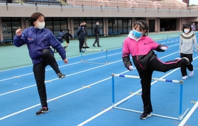 ハードルを跳ぶ際の脚の動きを教える横田華恋選手（左）＝加古川運動公園陸上競技場