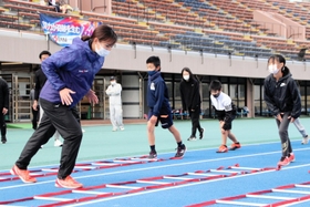 スタンディングスタートの姿勢を教える稲岡真由さん（左）＝加古川運動公園陸上競技場