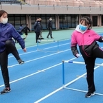 ハードルを跳ぶ際の脚の動きを教える横田華恋選手（左）＝加古川運動公園陸上競技場