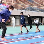 スタンディングスタートの姿勢を教える稲岡真由さん（左）＝加古川運動公園陸上競技場