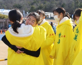 仲間と抱き合って喜びを表現するアンカーの藤田直子主将（左から２人目）＝滋賀県野洲市