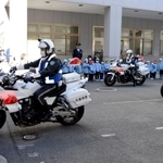 幼稚園児に見送られ、白バイで出発する署員ら＝加古川市平岡町新在家