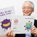 手洗いの大切さなどを解説した日本語の絵本（左）とバングラデシュ版を持つ山庄司志朗さん＝加古川市平岡町新在家、日の出医療福祉グループ