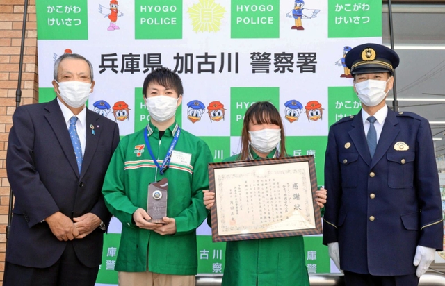 パネルの前に並ぶ鈴木田竜馬さん（左から二人目）、妻祐岐加さん（左から三人目）＝セブン－イレブン加古川平岡山之上店