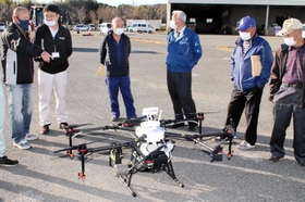 「スマート農業機械展示・実演会」で農薬散布用のドローンを見学する農業者ら＝２０２０年１２月、稲美町北山