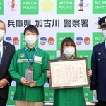 パネルの前に並ぶ鈴木田竜馬さん（左から二人目）、妻祐岐加さん（左から三人目）＝セブン－イレブン加古川平岡山之上店